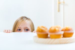 Девочка смотрит на кексы
