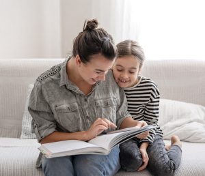 Мама читает книгу с дочкой