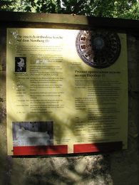 Информационная доска о храме на стене кладбища