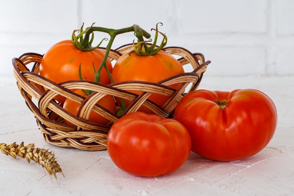 closeup ripe red and yellow tomatoes on a wicker basket an ear of wheat - Маленькие хитрости приготовления пищи