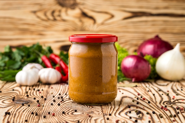 composition of squash caviar in jar and ingredients on wooden background - Кабачковая икра с сельдереем