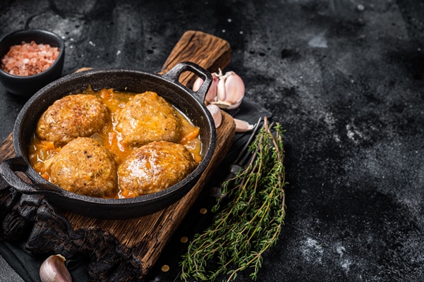 fish balls with tuna in tomato sauce in a pan black background top view copy space - Рыбные котлеты