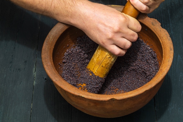 grinding poppy seeds in an old clay pot for making kutya or pies - Сочиво