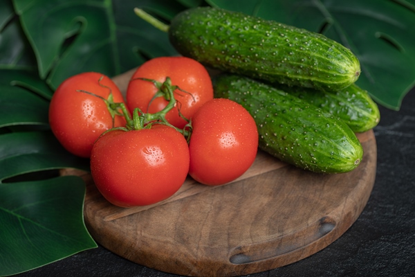 pile of fresh organic vegetables cucumbers and tomatoes on wooden board with green leaves - Овощи, бобовые, грибы: полезные советы