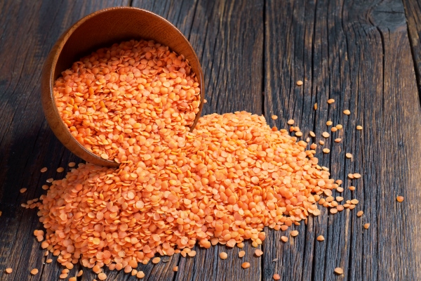 red lentils in bowl and near on dark wooden background - Чечевичные постные блинцы