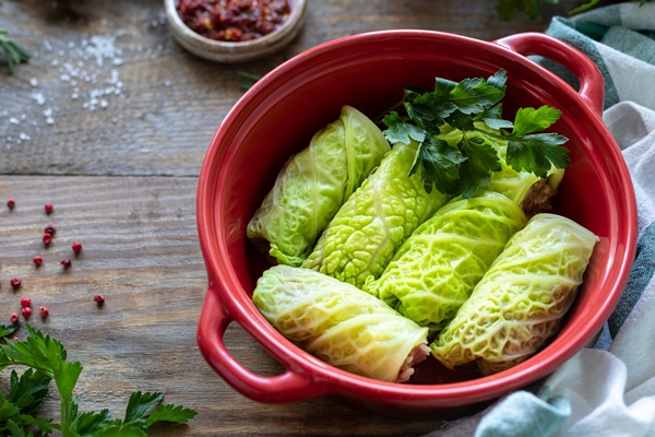 savoy cabbage rolls stuffed with meat rice and vegetables on a rustic table - Постные голубцы