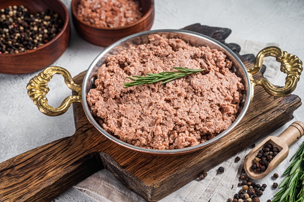 uncooked vegan mince meat raw plant based meat with thyme in skillet white background top view - Постные котлеты из фасоли