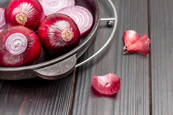 whole onion and sliced purple onions into rings in frying pan husks on table dark wooden background copy space top view - Постные картофельные зразы