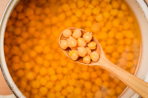 wooden spoon with boiled chickpeas over a pan - Фалафель
