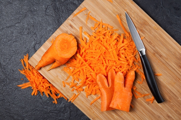 a fashion trend is eating deformed and ugly vegetables grated carrots on a cutting board - Икра грибная консервированная