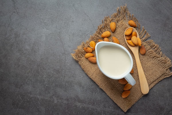 almond milk with almond on dark background - Соевые блинцы на миндальном молоке
