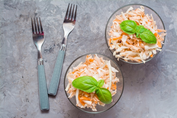 american ready to eat cole slaw salad of cabbage celery carrots and apples with basil leaves in glass bowls in the ingredients for cooking on the table the concept of healthy and proper nutrition - Салат из клюквы