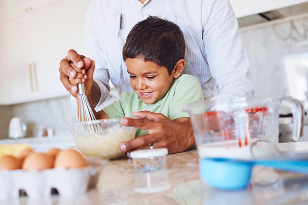 baking kid and father in kitchen learning to make cake cookies or biscuits in home support care and bonding with parent teaching boy how to cook bake and cooking with eggs wheat flour and milk - Блины по рецепту семьи Мейендорф № 2