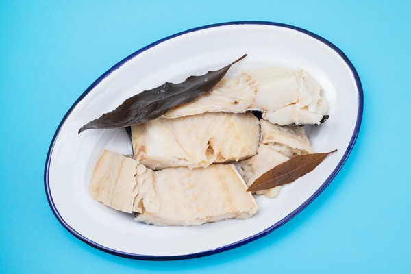 boiled cod fish with bay leaf on white dish on blue - Постные блинчики с рисом и рыбой