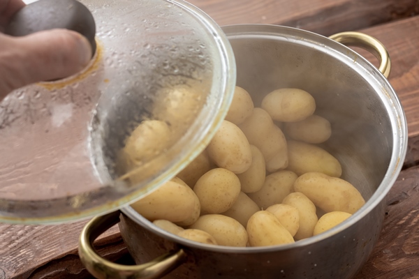 boiled young small potatoes in a saucepan on a wooden background - Постные блинчики с картофельной начинкой