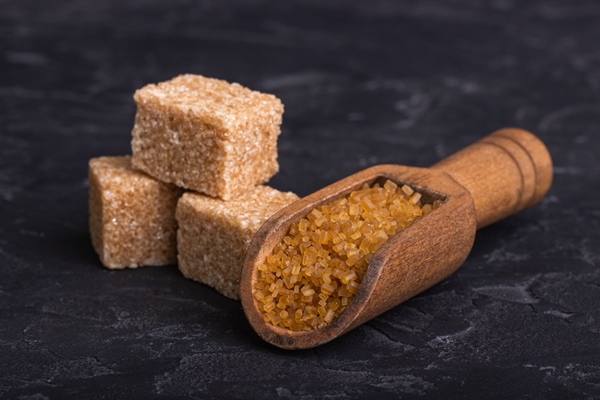 brown cane sugar cubes in a clay bowl with a wooden spoon - Постные блинчики с карамельным яблоком