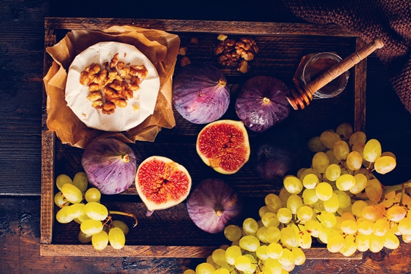 camembert cheese with figs walnuts honey and thyme served for a dinner in dark key on wooden surface in retro style - Библия о пище