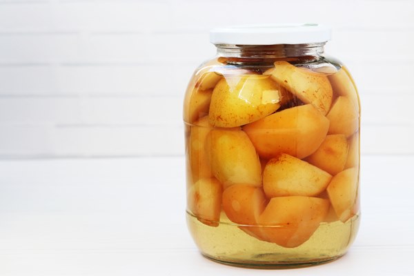 canned apples in syrup in a jar on a white background - Компот из айвы