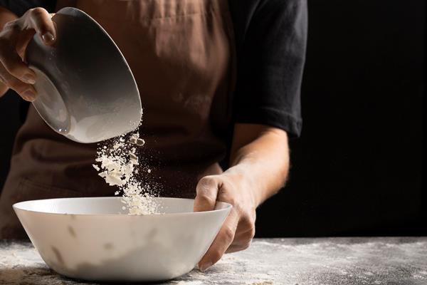 chef adding flour to bowl to create dough - Постные закусочные блинцы на соевом молоке