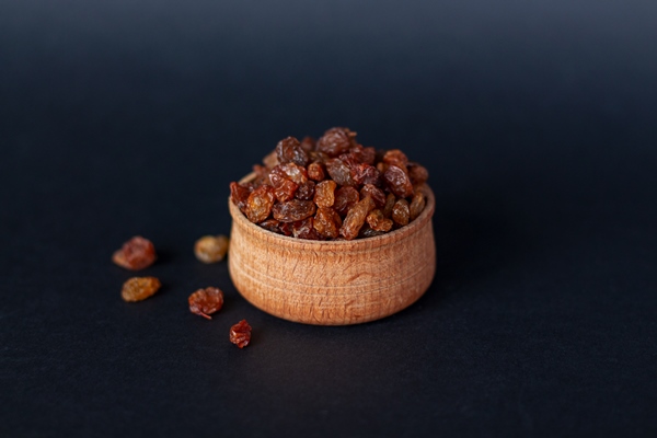 close up of handful of brown raisins on wood - Кулич бабушкин