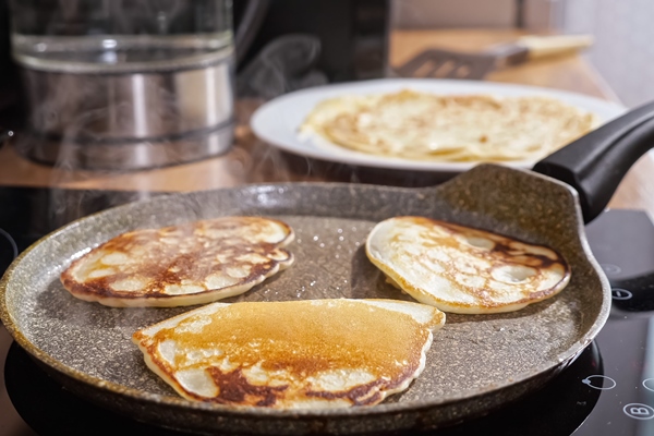 close up of mini pancakes on a hot frying pan - Постные блинцы на кокосовом молоке