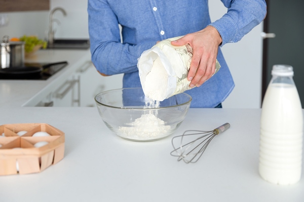 closeup of man in blue shirt preparing dough on the kitchen at home - Кулич домашний