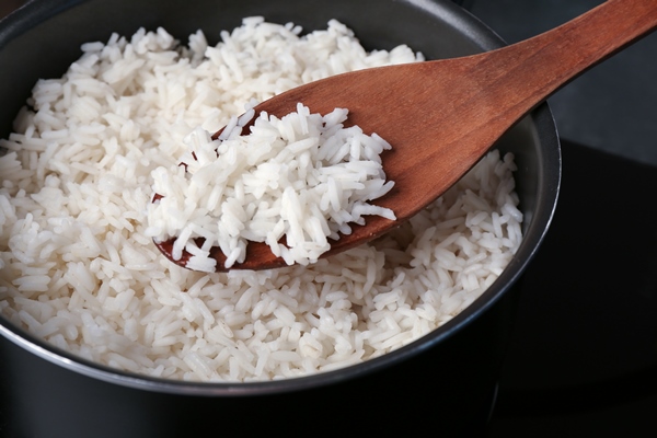 cooked rice in saucepan with spoon - Постные блинчики с рисом и рыбой