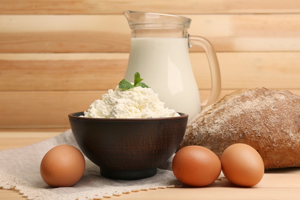 cottage cheese in clay bowl with jug of milk loaf of bread and eggs on wooden planks - Пасха с фруктовым желе