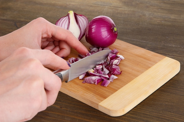 cutting purple onion on wooden background - Рассольник с перловкой на зиму