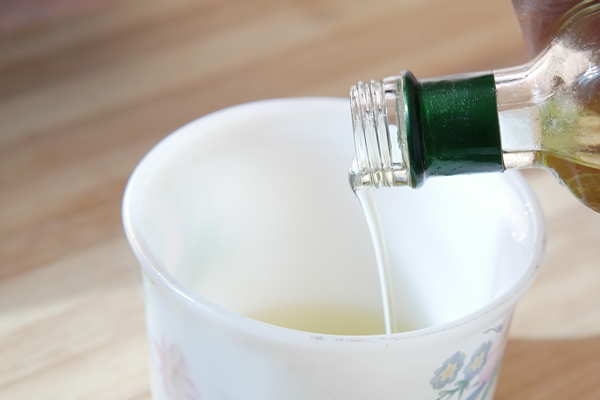 detail shot of pouring vegetable oil in a cup - Постные яблочные блинцы на соевом молоке