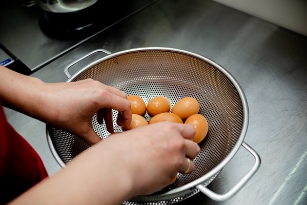 female hand washing hen eggs - Яйца, крашенные каркаде