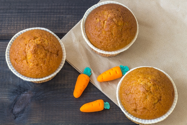 freshly baked carrot muffins decorated marzipan carrots on wooden background national carrot cake day - Кулич морковный с пряностями