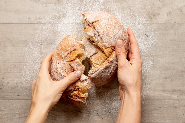 hands breaking a delicious bread - Библия о пище