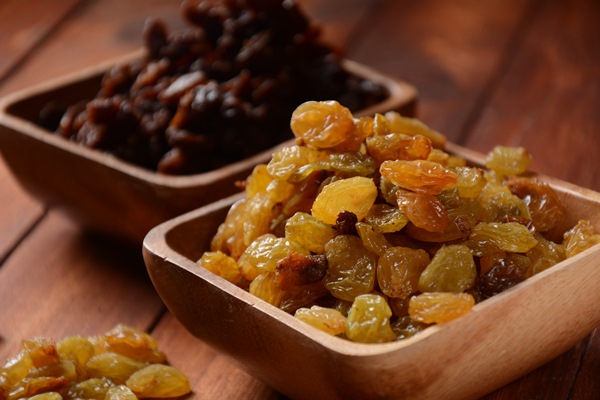 heaps of yellow and dark raisins in a wooden bowls dried grapes - Постные оладьи (старинный рецепт)