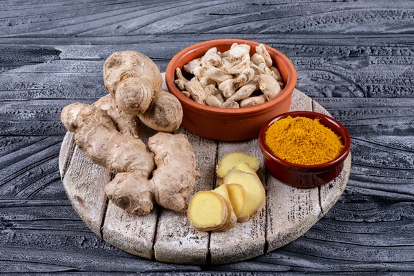 high angle view ginger in bowls with ginger slices and powder on wood and dark wooden background - Библия о пище