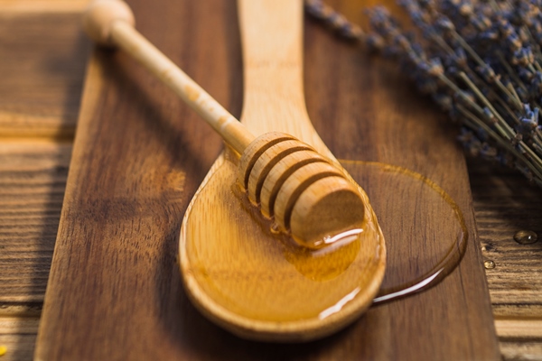 honey dipper on wooden spoon over the chopping board - Постные блинчики со свёклой и орешками