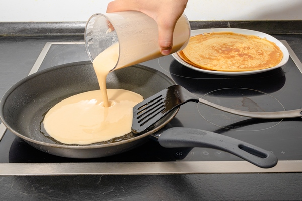 male human hand fill dough for pancake into pan while cooking breakfast for family 1 - Постные блинцы из миндальной муки