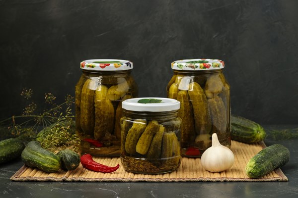 marinated cucumbers in jars are located on a table on a dark background - Огурцы "Как из бочки"