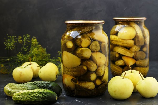 marinated cucumbers with apples in jars are arranged - Постные блинцы на рассоле