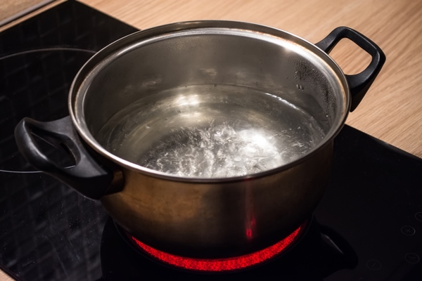 metal pan with boiling water on the induction cooker red hot plate - Медовый перец на зиму