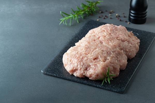 minced chicken or turkey meat on black board with rosemary and spices copy space - Пельмени с судаком
