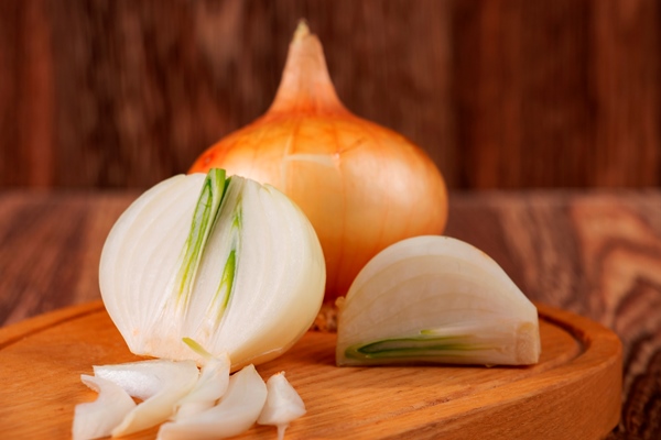 onions in a cut on a rustic wooden table - Овощная запеканка с курицей