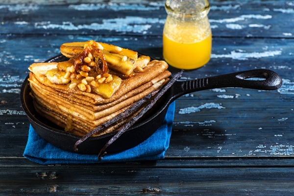 pancakes caramelized with bananas honey and nuts in a castiron frying pan thin pancakes or crepes - Постные блинчики на чае с пряной начинкой