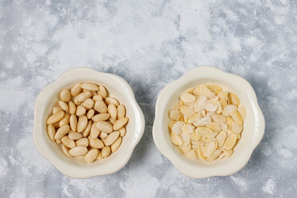 peeled blanched and unblanched whole almonds in ceramic bowls on grey concrete 1 - Постные тыквенно-миндальные блинцы