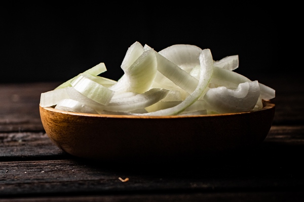 pieces of onion in a wooden plate on the table - Постные пресные блинцы на картофельном отваре