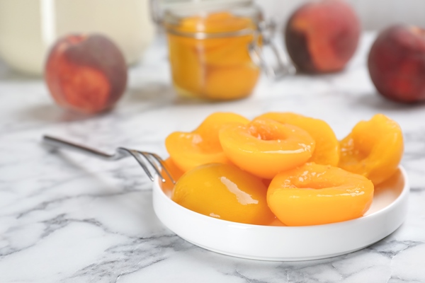 plate with conserved peach halves on marble table 1 - Консервированные персики в сиропе