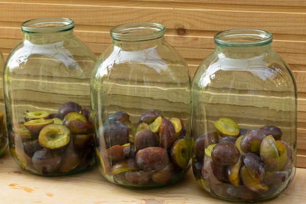 plums placed in jars plum compote in the cooking process close up - Слива в собственном соку