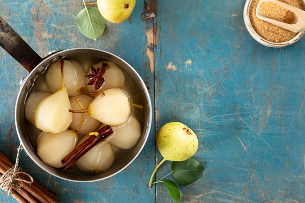 poached pears with spices in syrup on a blue wooden background delicious dessert for the holiday top view - Целые груши в сиропе