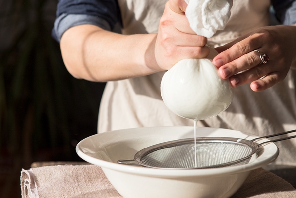 preparation of almond milk woman straining the milk through a cheesecloth - Пасха с фруктовым желе
