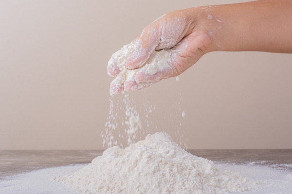 putting all purpose flour to make dough - Постные блинцы из манки с луком и морковью